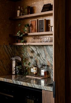 a kitchen with marble counter tops and wooden shelves