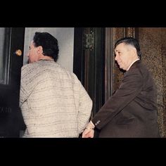 two men shaking hands in front of a door