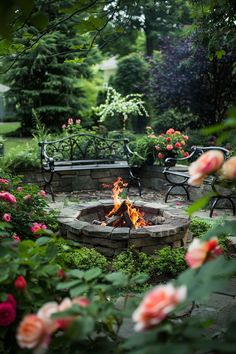 an outdoor fire pit surrounded by flowers and benches in the middle of a garden area