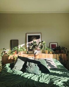 a bed with green sheets and plants on it