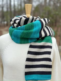 a woman wearing a striped scarf on top of a mannequin