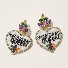 two heart shaped brooches with mardi gras written on them