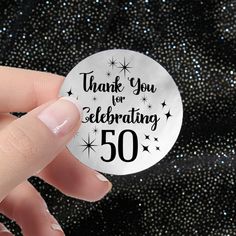 a hand holding a sticker that says thank you for celebrating 50 years