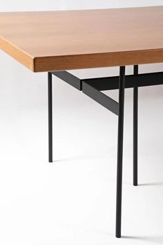 a wooden table with black metal legs on a white background