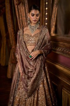 This lehenga set features intricate embroidery in sequin, bead and crystal on a deep mustard tissue organza base. The elbow sleeve blouse has tassels at sleeve hem and waist and is paired with a contrasting maroon tissue dupatta with matching heavy embroidery.From Seema Gujral's Falaknuma collection. DELIVERY TIMEPlease allow 8-12 weeks for your outfit to arrive. FABRIC DETAILSTissue Organza Professional cleaning only. Glamorous Saree Choli For Eid, Brocade Sets With Mirror Work For Reception, Wedding Lehenga With Mirror Work In Brocade, Brocade Traditional Wear With Mirror Work For Reception, Festive Brocade Lehenga With Mirror Work, Traditional Brocade Lehenga With Mirror Work, Bollywood Brocade Sets With Mirror Work, Bollywood Style Sets With Mirror Work In Brocade, Bollywood Style Sets With Brocade And Mirror Work