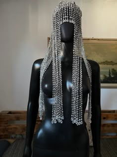 a black mannequin with white beads on it's face and headdress