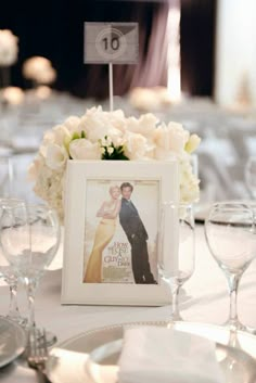 the table is set with white flowers and wine glasses