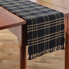 a black and white plaid table runner on a wooden dining room table with wood legs