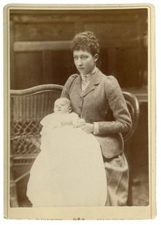 an old black and white photo of a woman holding a baby