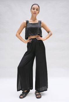 Model is posing in a studio. She is wearing a black crop top and matching wide leg pant in a black silky fabric by Fauna The Label. Black Viscose Wide Leg Bottoms, Black Full Length Viscose Bottoms, Black Viscose Wide Leg Pants, Stretch Viscose Ankle-length Wide Leg Pants, Ankle-length Solid Viscose Wide Leg Pants, Black Wide Leg Viscose Pants, Stretch Viscose Straight Leg Pants, Versatile Straight Leg Viscose Bottoms, Stretch Straight Leg Viscose Pants