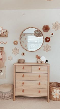 a bedroom with a dresser, mirror and pictures on the wall above it is decorated with flowers