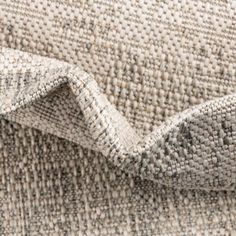 an upholstered fabric textured with grey and white colors, close - up