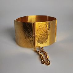 Brazalete fabricado a mano con textura que emula la piel de serpiente. Base de latón y un baño de oro amarillo o rosa (1 mcr). Las medidas pueden variar ligeramente. Ancho: 3 cm Largo estirado: 18 cm Elegant Gold Brass Cuff Bracelet, Luxury Gold Metal Cuff Bracelet, Gold Oyster Bracelet In Brass, Gold Oyster Bracelet Made Of Brass, Matte Gold Bangle Bracelet For Formal Occasions, Gold Plated Cuff Bracelets, Yellow Gold Metal Cuff Bracelets, Luxury Gold Cuff Bracelets, Luxury Gold Hammered Cuff Bracelet