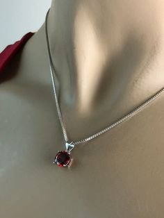 "Sterling Silver Garnet Necklace, Garnet Cubic Zirconia Pendant Necklace NECKLACE FEATURES: Metal: All components are made from solid .925 Sterling Silver Model is wearing 16\" in length solid .925 Sterling Silver Chain Length available: 16\", 18\" or 20\" Stone: Garnet CZ THE Garnet CZ pendant measures 8mm in height Your Garnet Necklace will arrive in a gift box, beautifully wrapped and ready for gifting Please send me a convo if you have any questions before placing your order. Please also vie Elegant Red Jewelry For Birthday, Red Round Stone Necklaces For Anniversary, Red Round Birthstone Necklace For Anniversary, Red Necklace With Prong Setting As Gift, Red Round Cut Necklace For Anniversary, Classic Red Birthstone Necklace As Gift, Classic Red Birthstone Necklace For Gift, Elegant Red Necklace For Birthday Gift, Elegant Red Jewelry For Birthday Gift