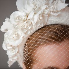 a close up of a woman's head wearing a white hat with flowers on it