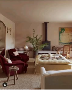 a living room filled with furniture and a fire place in the middle of it's wall