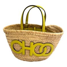 Elevate your summer style with the Jimmy Choo Logo Crossbody Tote Bag, crafted from natural raffia with citron yellow leather trim. This chic tote features the iconic Jimmy Choo logo detailing, two leather handles, and a convenient tie closure. Its interior is unlined keeping the natural raffia consistent throughout the bag and includes one pocket for organization.  Perfect for any occasion, this bag combines luxury with practicality. Add a touch of sophistication to your look with Jimmy Choo's Designer Straw Bag With Handles For Vacation, Designer Summer Straw Bucket Bag, Designer Summer Straw Bag With Top Handle, Designer Summer Bags With Leather Handles, Designer Beach Straw Bag With Handles, Designer Straw Bag For The Beach, Designer Beach Straw Bag, Designer Woven Summer Bags, Designer Woven Bags For Summer