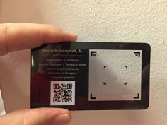 a person holding up a business card with qr code on it