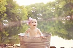 a baby sitting in a tub with soap bubbles