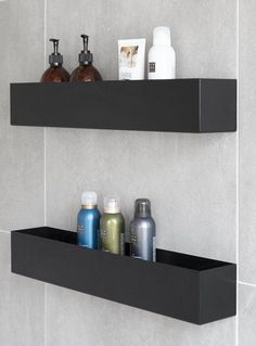 two black shelves with soap and lotion on them