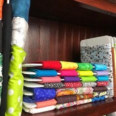 a shelf filled with lots of different colored cloths