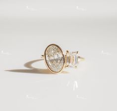 an engagement ring with a pear shaped diamond set in yellow gold, on a white background