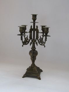 an ornate bronze candelabra with five candles on it's base,