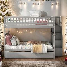 a white bunk bed sitting next to a christmas tree with lights on the top and bottom