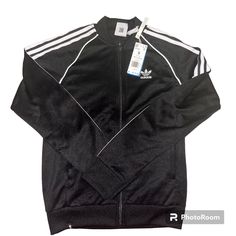 Slim Fit Ribbed Collar 60% Recycled Polyester, 40% Cotton Interlock Heavyweight Fabric Classic Adidas Track Jacket Front Zip Pockets Ribbed Cuffs And Hem Imported Product Color: Black / White Product Code: Gf0198 Fitted Sports Outerwear With Three Stripes, Casual Three Stripes Outerwear For Fall, Casual Spring Outerwear With Three Stripes Branding, Casual Three Stripes Fall Outerwear, Fitted Outerwear With Three Stripes For Fall, Fitted Three Stripes Outerwear For Fall, Long Sleeve Outerwear With Three Stripes For Spring, Casual Fall Outerwear With Three Stripes, Casual Outerwear With Three Stripes Branding