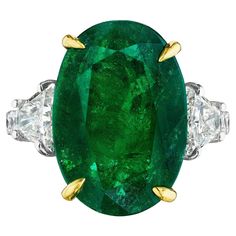 • Platinum & 18KT Two Tone • Size 6.5 • 9.68 Carats • Number of Oval Emeralds: 1 • Carat Weight: 8.54ctw • 16.80 x 11.70mm • Number of Brilliant Trapezoid Diamonds: 2 • Carat Weight: 0.64ctw • Number of Round Diamonds: 10 • Carat Weight: 0.50ctw • This ring showcases an 8.54ct oval cut green emerald center stone. The emerald is flanked by 2 brilliant cut trapezoid diamond side stones, and round diamonds down the band. The green emerald is secured by 18KT yellow gold prongs, highlighting its colo Luxury Green Oval Gemstones, Gia Certified Oval Green Diamond Ring, Green Oval Diamond Ring With Vvs Clarity, Oval Green Diamond Gemstones, Gia Certified Green Oval Ring, Oval Green Gemstones For Formal Occasions, Oval Brilliant Cut Emerald Gemstones, Gia Certified Oval Emerald Gemstone, Gia Certified Oval Emerald