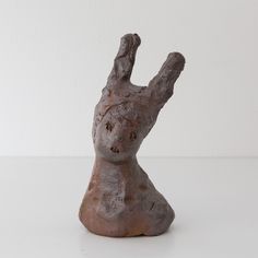 a clay sculpture of a hand reaching up to the side with its fingers in the air