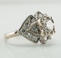 an old - fashioned diamond ring is shown on a white surface with the center stone surrounded by smaller diamonds