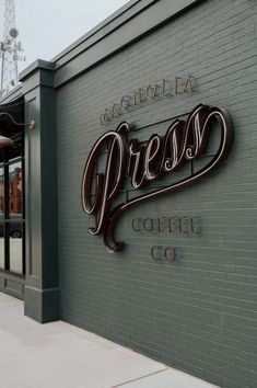 there is a sign that says coffee co on the side of this building in front of a brick wall