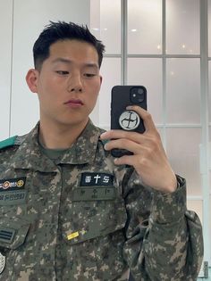 a man in uniform taking a selfie with his cell phone