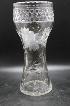 a clear glass vase with white flowers on the inside and bottom, sitting on a gray surface