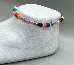 Introducing this cheerful handmade anklet for her! Made with a variety of colorful glass beads, this ankle bracelet is the perfect accessory for springtime and beyond. You'll love the way it looks with your favorite sandals or by the pool.  It measures approximately 9 inches with an additional 1 inch extension, ensuring a comfortable fit for most ankle sizes. The multicolored design means you can wear this anklet all year round, adding a touch of whimsy to any outfit. This anklet also makes for Multicolor Round Beads Anklets As Gift, Multicolor Round Beads Anklets For Gift, Adjustable Multicolor Anklets For Spring, Multicolor Beaded Chain Anklets As Gift, Gift Multicolor Round Beads Anklets, Gift Multicolor Round Bead Anklets, Multicolor Beaded Anklets For Party, Multicolor Beaded Anklets For Festivals, Spring Multicolor Adjustable Anklets