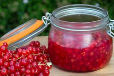 a jar filled with liquid next to some berries