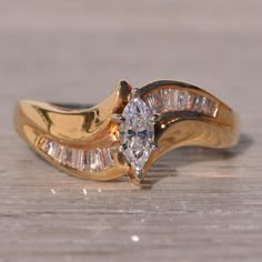 a close up of a diamond ring on a wooden surface