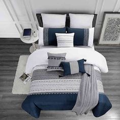 a bed with blue and white comforters in a room