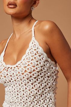 a woman wearing a white crochet top