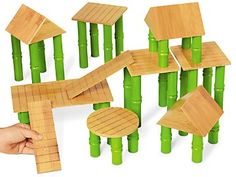 the wooden toys are made to look like bamboo sticks and houses with hands holding them