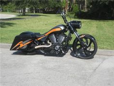 an orange and black motorcycle is parked on the street