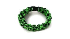 a green and black bracelet on a white background