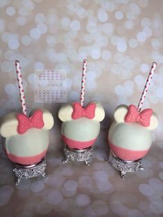 three mickey mouse cupcakes with pink and white frosting on them, decorated with candy canes