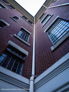 two windows on the side of a tall brick building