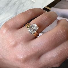 a woman's hand with a ring on it and a diamond in the middle