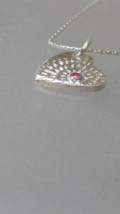 Made to Order: Handmade by Alison and finished by yours truly. Natural ruby (heat treated but not glass filled). Round cut with carat weight of 0.08ct that is bezel set. Lines lead out from ruby like a starburst. Pendant measures approximately 0.57 inches from top to bottom and 0.47 inches wide. Birthstone for July. Made of solid fine silver and comes with 18 inch sterling silver Cardano style chain with lobster clasp. Heart-shaped Jewelry With Bezel Setting For Valentine's Day, Heart-shaped Bezel Set Jewelry For Valentine's Day, Silver Birthstone Necklace With Heart Charm, Valentine's Day Jewelry With Bezel Setting, Ruby Heart Pendant Jewelry For Anniversary, Red Sterling Silver Birthstone Necklace For Anniversary, Anniversary Ruby Jewelry With Heart Charm, Silver Jewelry With Birthstone For Valentine's Day, Silver Sterling Silver Heart Cut Birthstone Necklace