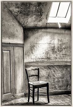 black and white photograph of a chair in an empty room