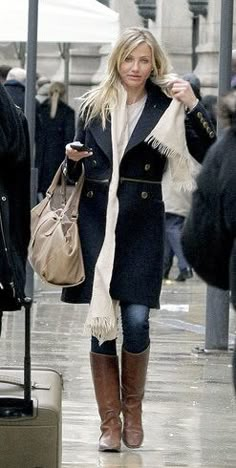 a woman is walking down the street with her luggage