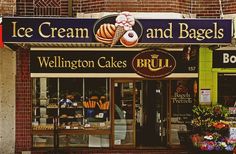 an ice cream and bagel shop on the corner of a street in front of a brick building